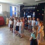Dzieci pięcioletnie ustawione w półkolu śpiewają piosenkę