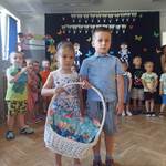 Chłopiec i dziewczynka trzymają kosz z prezentami dla sześciolatków