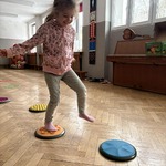 Dziewczynka stoi na krążkach sensorycznych