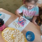 Dziewczynka wykleja pracę popcornem