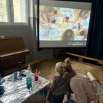 Przygotowany stolik oraz w tle prezentacja ze zdjęć
