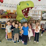 Dzieci pozują do zdjęcia z dużym dinozaurem