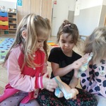 Dziewczynki oglądają rekwizyty przyniesione przez panią podolog