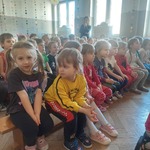 Dzieci siedzą i oglądają przedstawienie