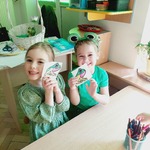 Dziewczynki pokazują pokolorowane żaby