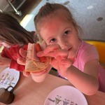 Dziewczynka pokazuje zrobioną przez siebie kanapkę