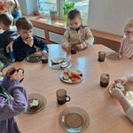 Dzieci siedzą przy stole podczas śniadania