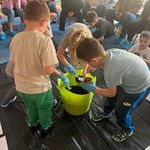 Dzieci nakładają ziemię do doniczki
