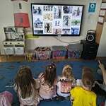 Dzieci oglądają zdjęcia na tablicy multimedialnej