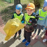 Dwóch chłopców trzyma żółty worek na śmieci