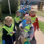 Dzieci idą w parach zbierać śmieci