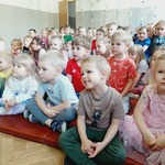 Dzieci oglądają przedstawienie siedząc na materacu