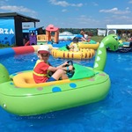 Chłopiec na dmuchanym dinozaurze