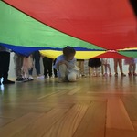 Dziecko siedzi pod chustą animacyjną